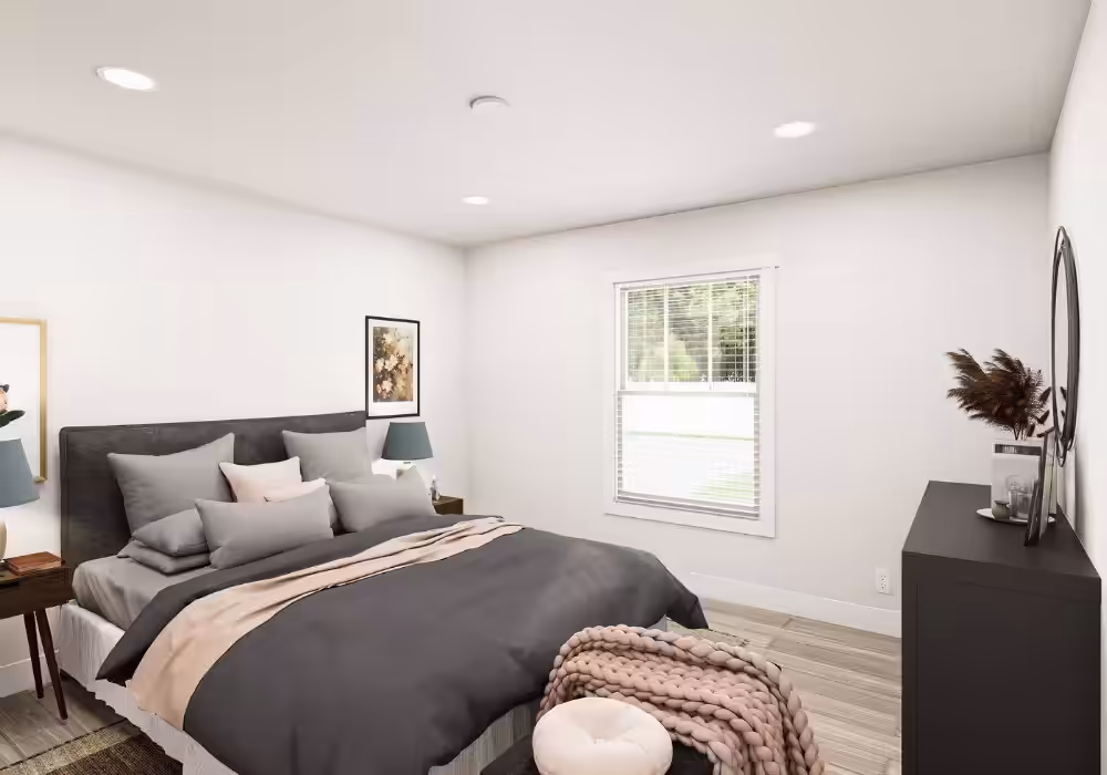 Modern bedroom with gray bedding, window with blinds, nightstand lamps, and dresser with mirror
