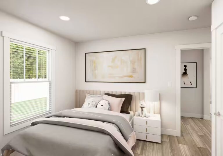 Bright bedroom with gray bedding, window blinds, nightstand with lamp, and framed abstract art