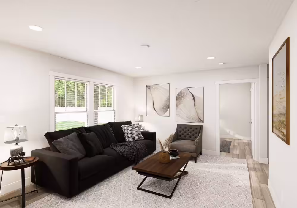 Modern living room with black sofa, gray armchair, wooden coffee table, and abstract wall art.