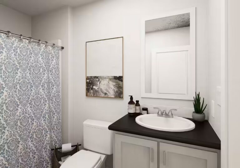 Bathroom with white toilet, patterned shower curtain, sink vanity with mirror, and potted plant
