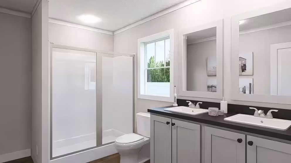 Bathroom with glass-enclosed shower, toilet, and double-sink vanity with mirrors above.